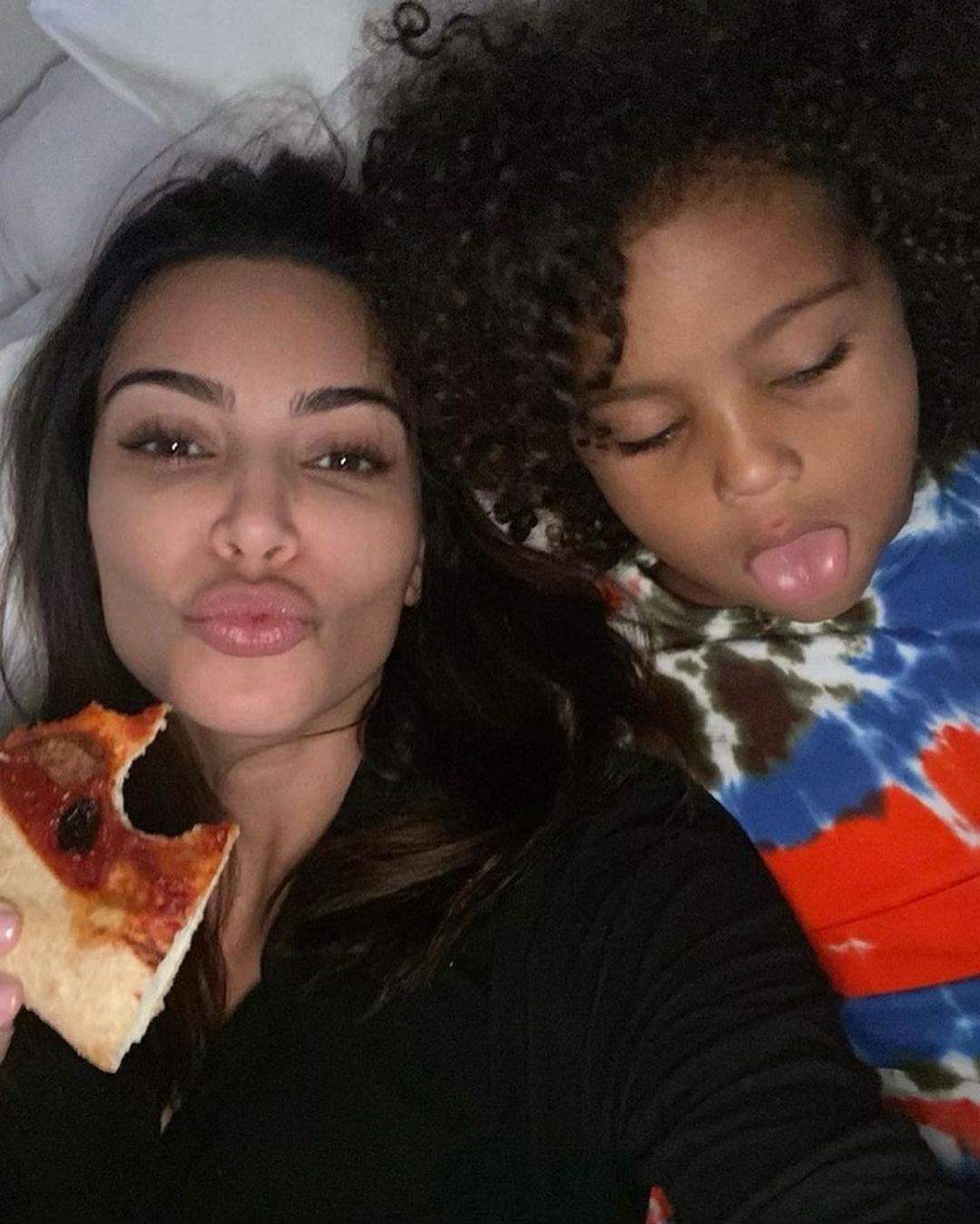 KIM KARDASHIAN POSING WITH SON SAINT SHOWING OFF LASH EXTENSIONS 
