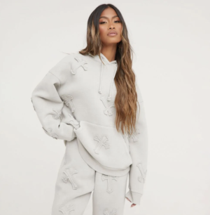brunette lady wearing oversized tracksuit with cross detail